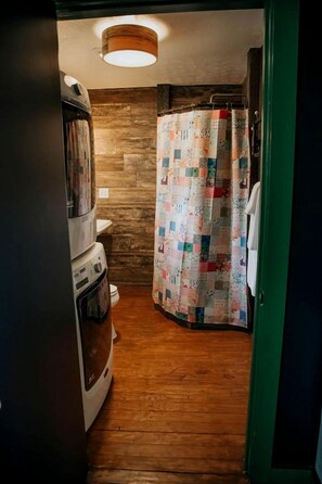 A narrow hallway with a wooden floor, a white oven, and a wooden wall with a hanging light fixture. - Family Glampsite: A Unique Cabin Retreat for Adventure in Tracy City, TN (Tracy City)