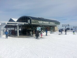 Ein Skigebiet mit einem überdachten Gebäude, auf dem 'Northwoods Gondola' steht.