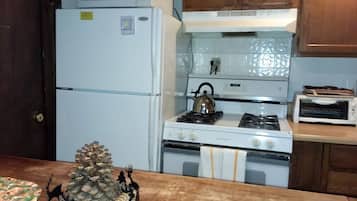 Une cuisine équipée d’un réfrigérateur, d’une cuisinière, d’un four à micro-ondes et d’un grille-pain.