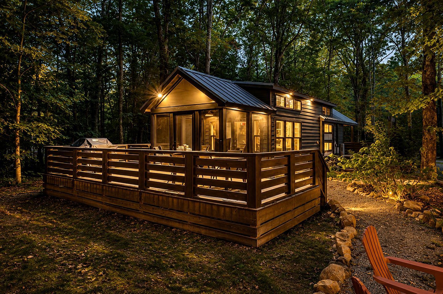 A cabin with a deck, surrounded by trees.