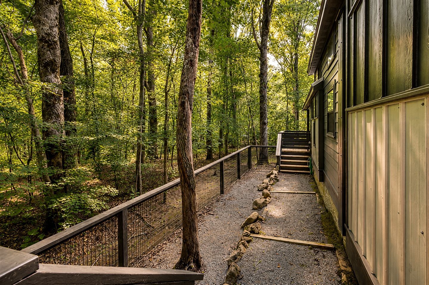 Una scala di legno che conduce a un edificio circondato da una foresta.