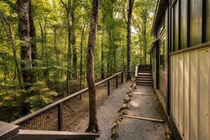 Eine Holztreppe führt zu einem Gebäude, das von einem Wald umgeben ist.