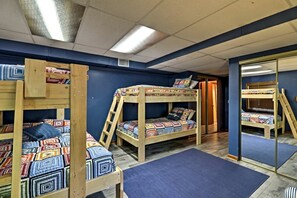 Una habitación con literas, un espejo y una puerta.