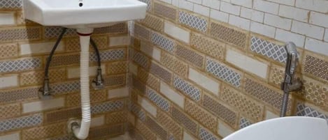 Une salle de bain avec un lavabo blanc, des toilettes et des carreaux décoratifs sur les murs.