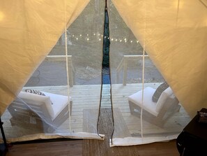 A tent with a view of outdoor seating and string lights.