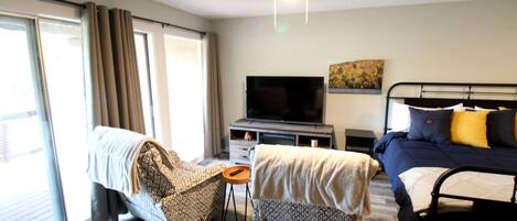 A hotel room with a bed, a sofa, a TV, and a small table.
