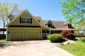 A two-story house with a garage, a covered porch, and a well-maintained lawn. - Charming Villa Ideal Escape for Big Groups in Branson, Missouri (Branson)