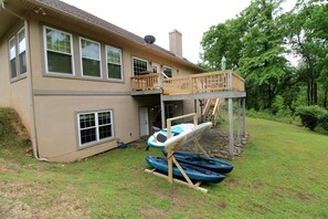 A two-story house with a balcony, a covered outdoor area, and kayaks. - Outstanding Cottage with Swimming Pool in Hot Springs, Arkansas (Hot Springs)