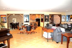 A living room with a piano, a sofa, a coffee table, and a dining area with chairs and a table. - Outstanding Cottage with Swimming Pool in Hot Springs, Arkansas (Hot Springs)