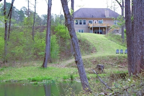 A house with a porch, a pond, and trees. - Outstanding Cottage with Swimming Pool in Hot Springs, Arkansas (Hot Springs)