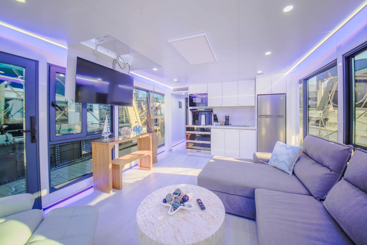 A modern living room with a sofa, a round coffee table, and a TV.