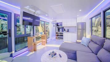 A modern living room with a sofa, a round coffee table, and a TV.