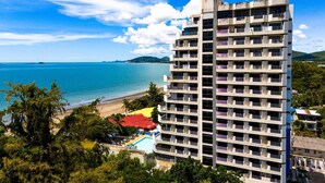 A high-rise hotel with multiple floors, balconies, and a pool area. - Beachfront Studio Condo-Seaview BW1 (Hua Hin)