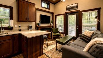 A modern kitchen with a large island, wooden cabinets, and a built-in TV.