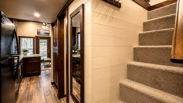 A kitchen with wooden cabinets, a countertop, and a dining area with a bench.