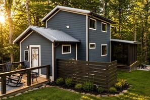 A two-story building with a deck and a small attached structure.