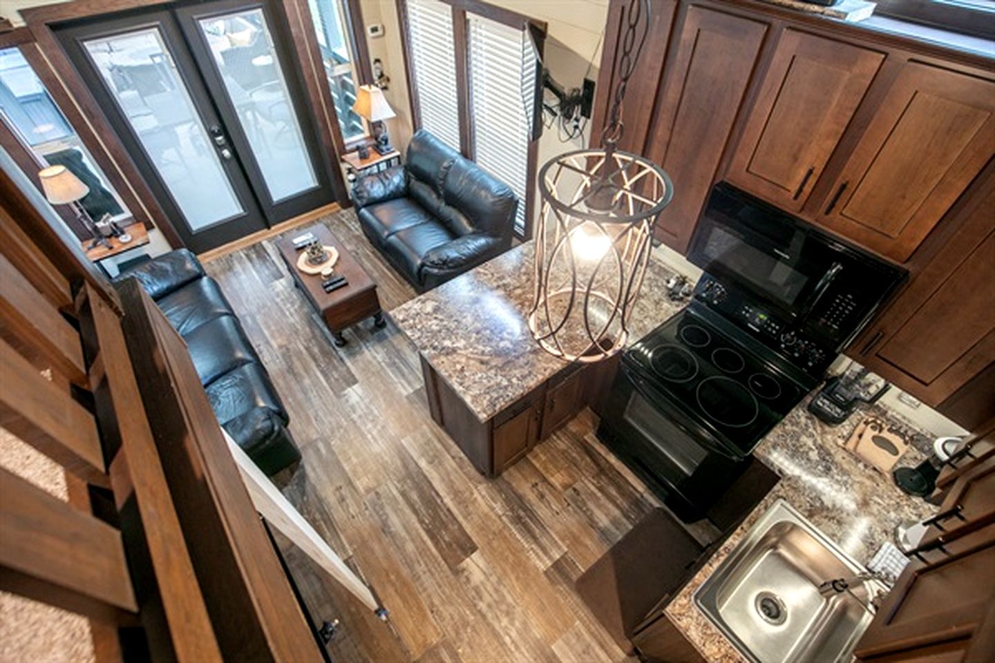 A kitchen with a built-in stove and a dining area with a sofa and table.