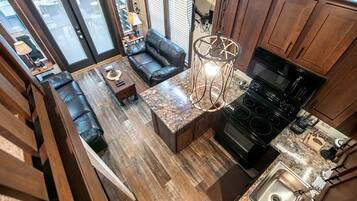A kitchen with a built-in stove and a dining area with a sofa and table.