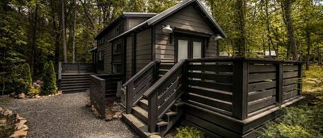 Une cabane avec une allée en gravier et une clôture en bois.