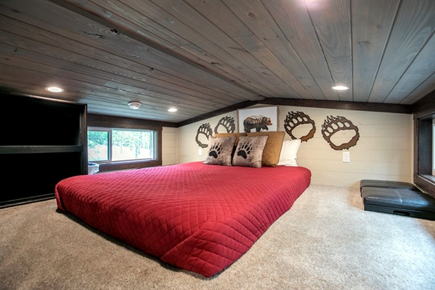 Quarto com uma cama grande, televisão de tela plana e janela.