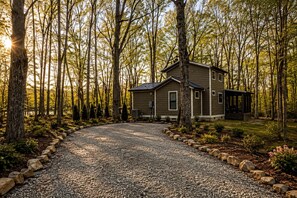 A two-story cabin with a gravel driveway surrounded by trees. - Incredible Cabin with Fire Pit and Great Vistas in Monteagle, Tennessee (Monteagle)