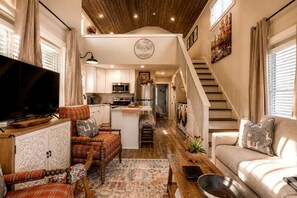 A spacious living area with a television, a sofa, a coffee table, and a fireplace. - Incredible Cabin with Fire Pit and Great Vistas in Monteagle, Tennessee (Monteagle)
