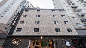 A hotel with a stone facade, a parking entrance, and a sign indicating a parking area. - Hotel Oneul (Incheon)