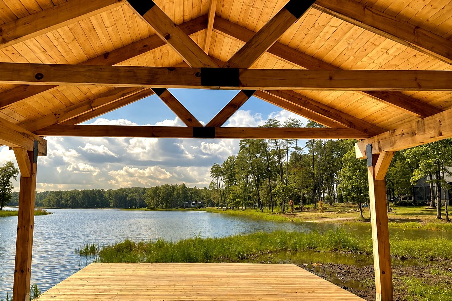 A wooden deck with a view of a lake and forest.