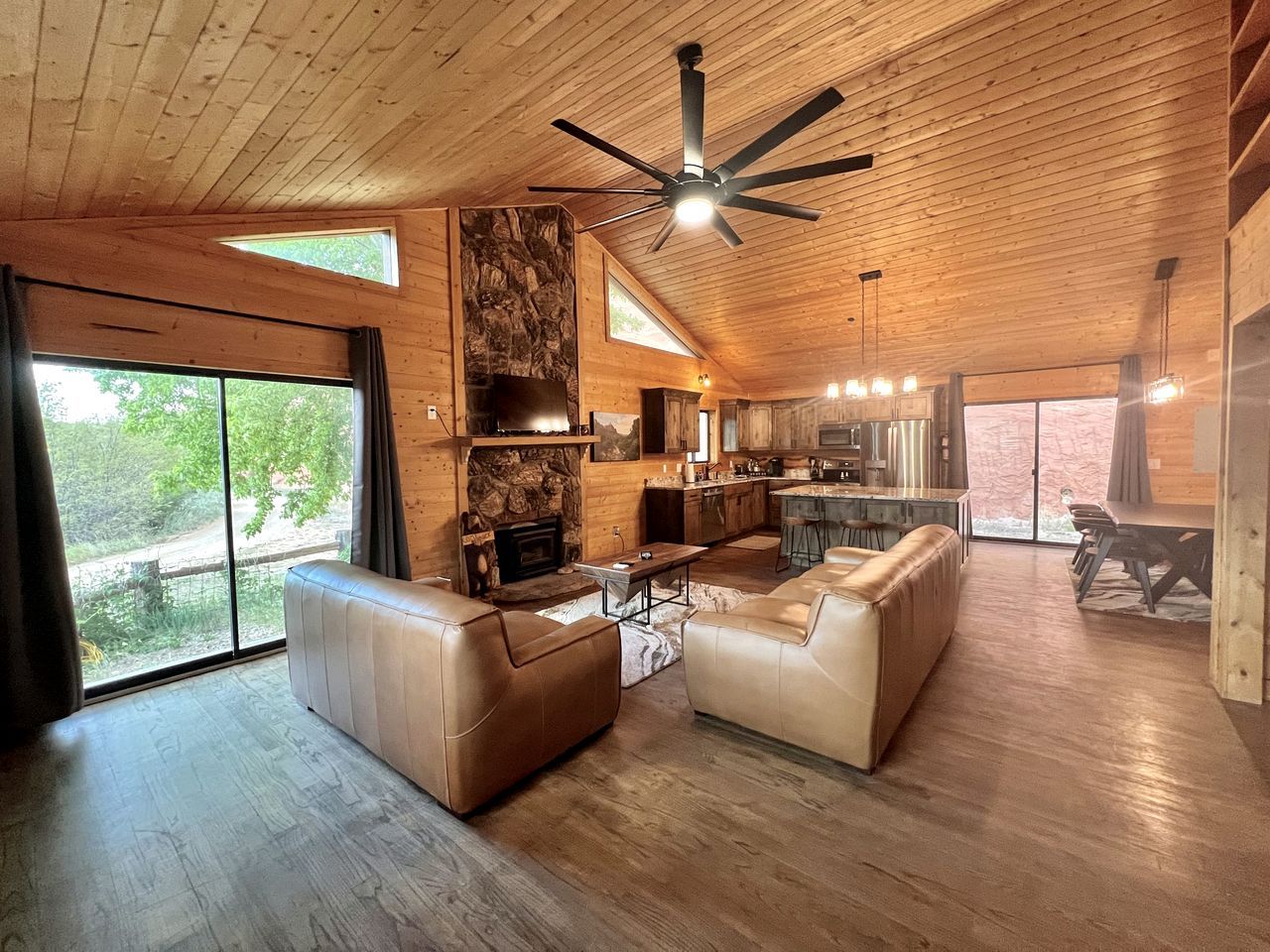 A spacious living area with a fireplace, leather sofas, and a large dining table.