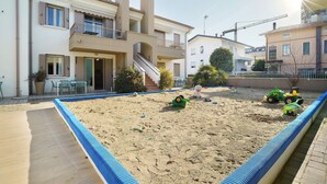 A residential area with a swimming pool, a staircase, and a playground with toys. - Apartment 'Valentina 1 - Ground Floor' with Shared Pool, Wi-Fi and Air Conditioning (Lido di Jesolo)