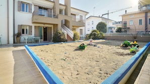 A residential area with a swimming pool, a staircase, and a playground with toys. - Apartment 'Valentina 1 - Ground Floor' with Shared Pool, Wi-Fi and Air Conditioning (Lido di Jesolo)