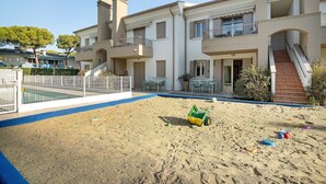 Edifício residencial com piscina, área de estar externa e escadaria.