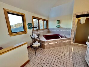 A bathroom with a bathtub, a window, a towel rack, and a tiled floor. - Glorious Cottage Placed in a Secluded Area in Stratton, Vermont (Stratton)