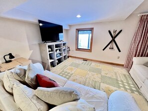 A bedroom with a bed, a TV, a window, and a wall-mounted decoration. - Glorious Cottage Placed in a Secluded Area in Stratton, Vermont (Stratton)