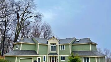 A two-story house with a garage, a front porch, and a symmetrical design.