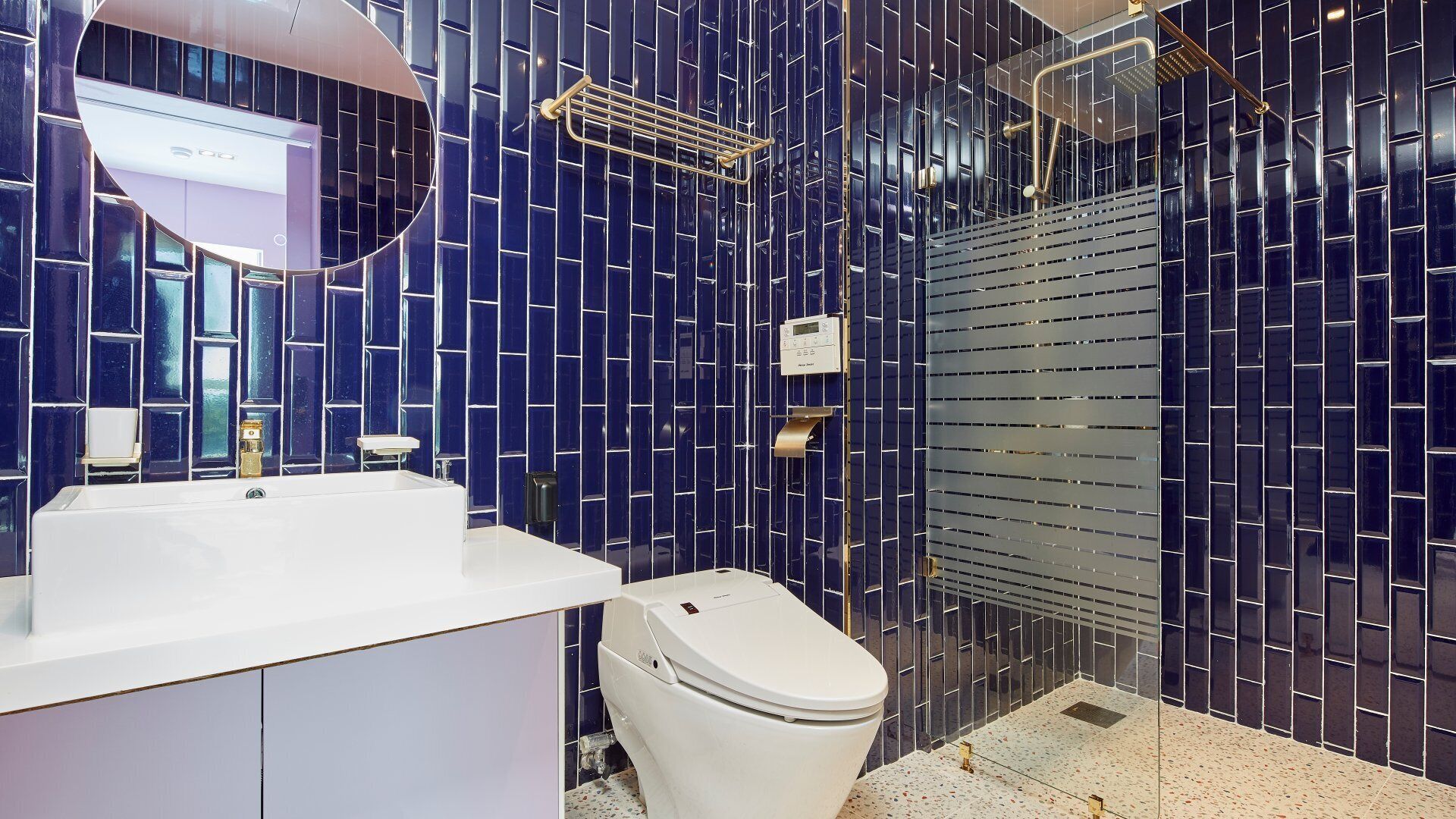 Een moderne badkamer met een wit wastafelmeubel, toilet en douchehoek.