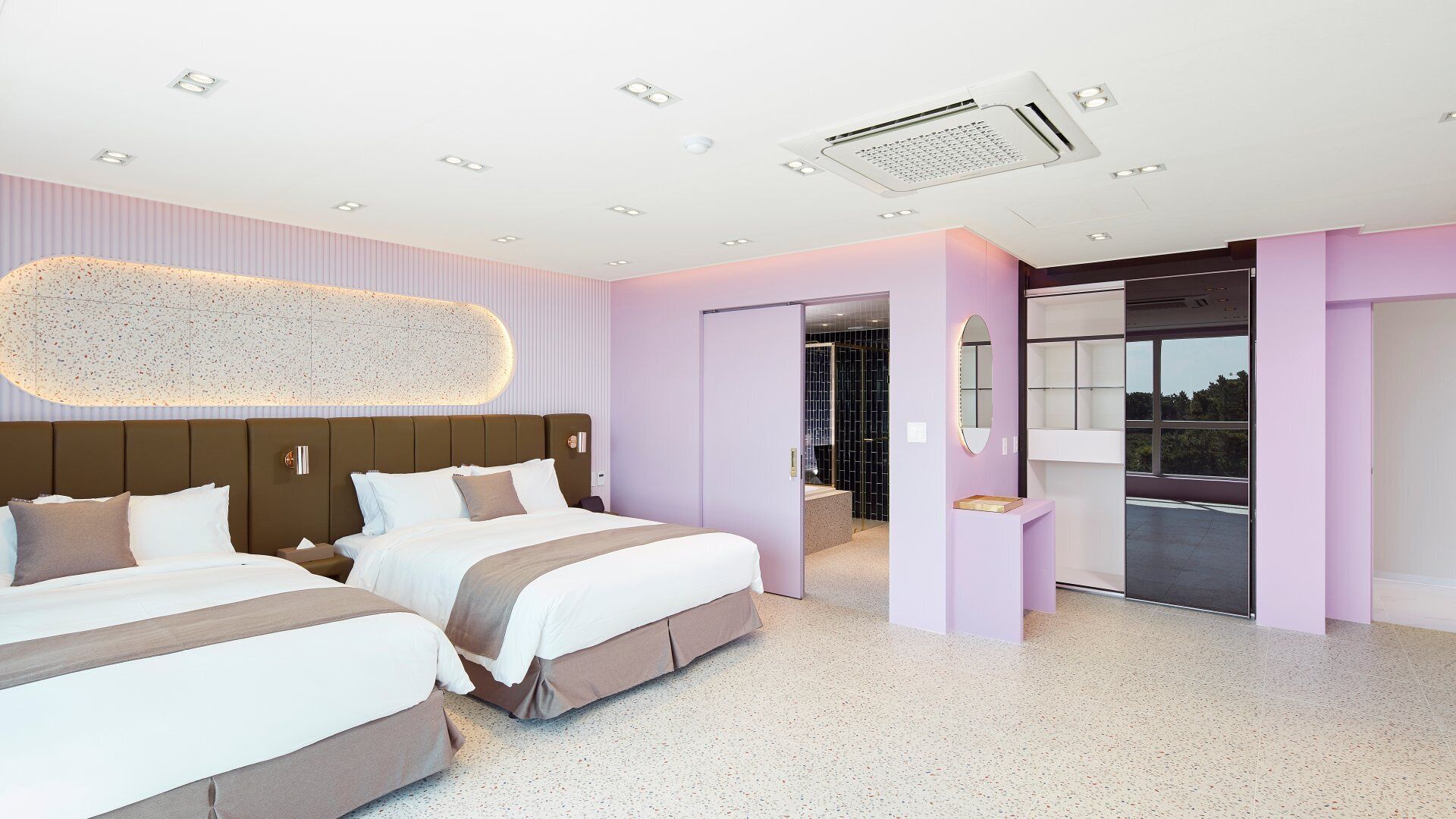 A modern hotel room with two beds, a large mirror, and a view of the outdoors.