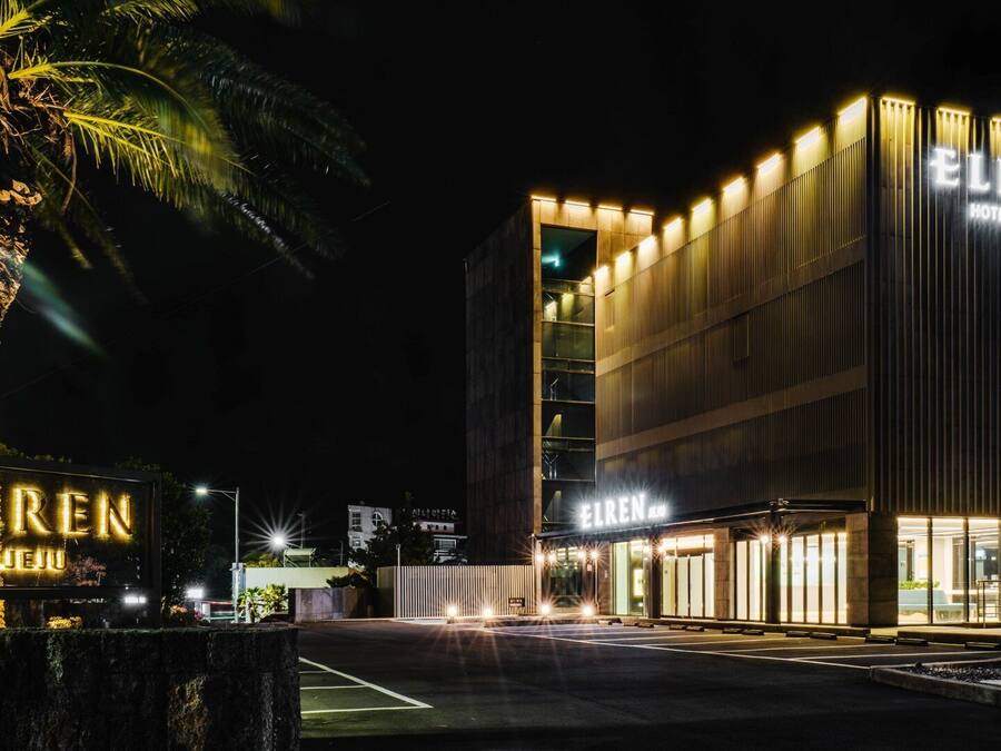 Een modern hotel met verlichte signage, een opvallende ingang en een goed verlichte gevel.