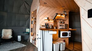 A compact kitchen with a microwave, sink, and storage cabinets.
