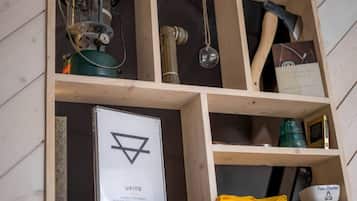 A wooden shelf with various items including a book titled 'UKIYO,' a fire starter, and a metal container.