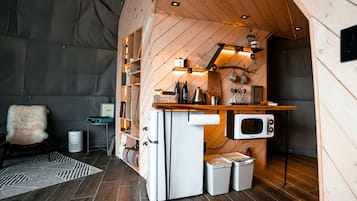 A compact kitchen with a microwave, sink, and storage cabinets.