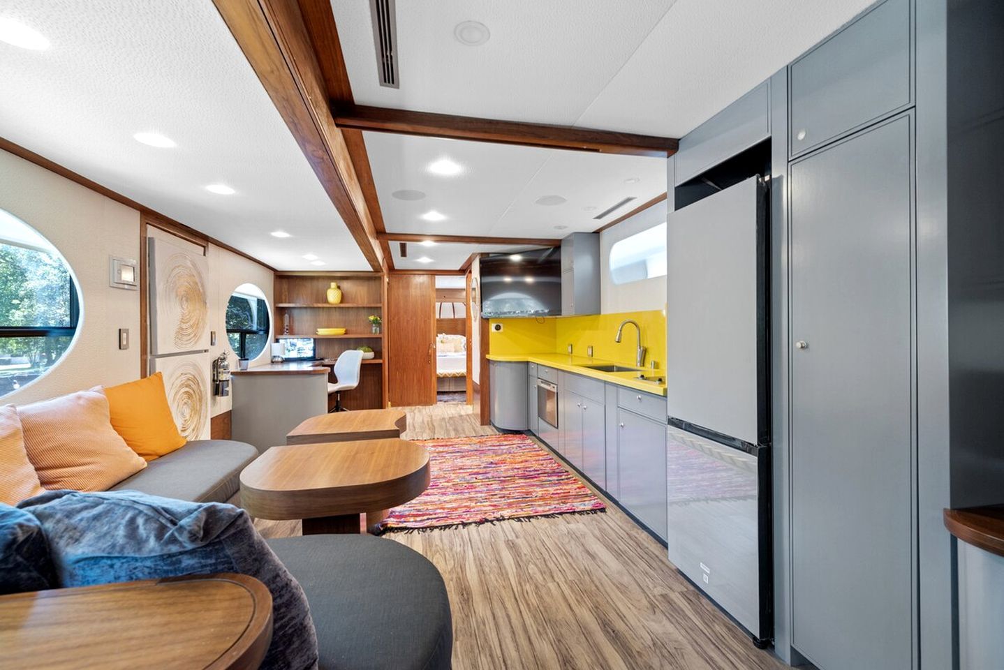 A compact living space with a kitchenette, seating area, and a view through a window.