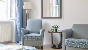 A room with two armchairs, a small table with a plant, a lamp, and a mirror on the wall. - 2BR Apartment Long Stay Up to 6 Guests (Vienna)