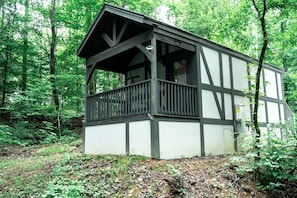A cabin with a balcony, surrounded by trees. - Tiny Home Cottage Near the Smokies #4 Stella, Sevierville, Tennessee (Sevierville)