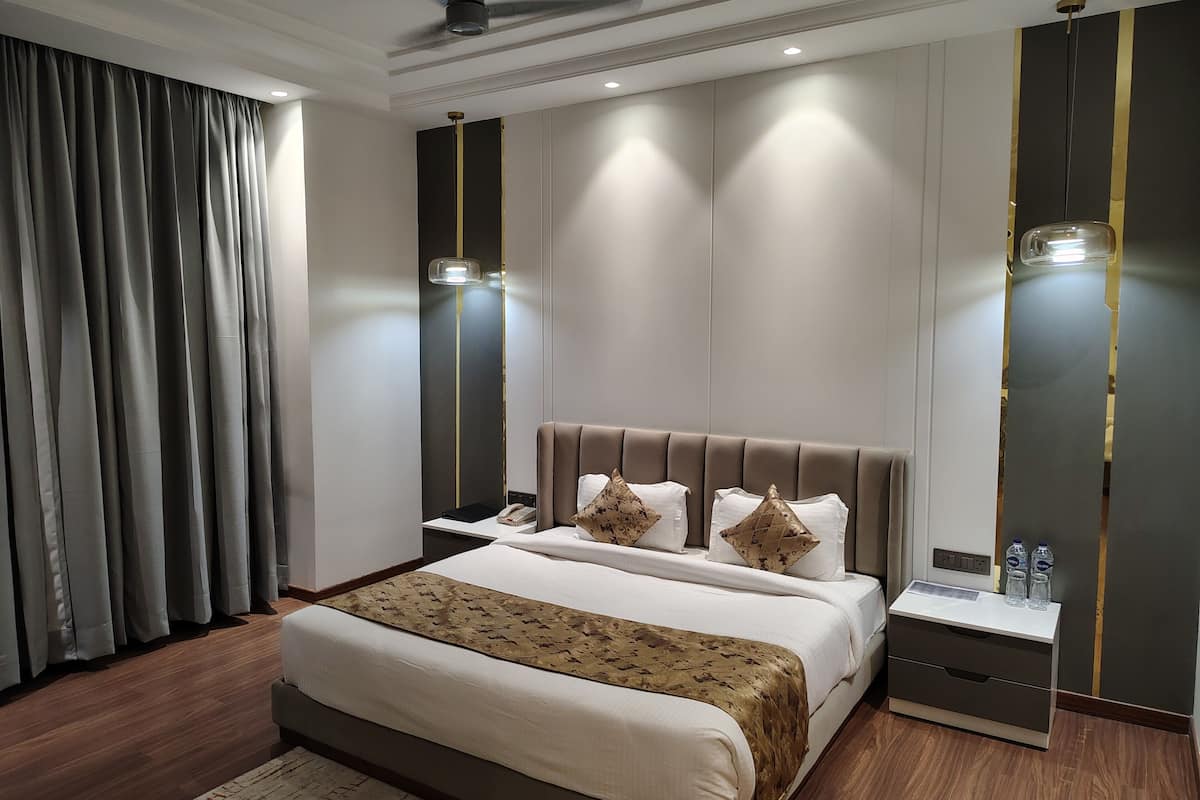 Una habitación de hotel moderna con una cama grande, mesitas de noche, un escritorio y una silla.