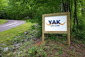 Une enseigne pour le Yak Eco-Camp, avec un cadre en bois et un fond blanc.