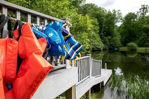 Une jetée équipée de gilets de sauvetage et d’une rambarde surplombant une étendue d’eau calme.