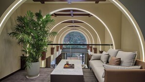 Un interior moderno con techo curvo, un sofá, una mesa de centro y una planta en maceta.