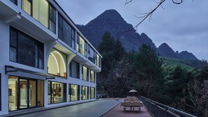 Un hotel moderno con balcón con vistas a un paisaje montañoso.