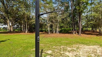 A metal structure with a sign reading 'Vista Verde Farm Retreat' in a wooded area with grass and trees.